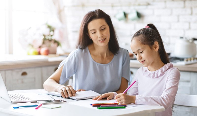 beautiful-mother-helping-her-daughter-with-homewor-BELMZW4.jpg